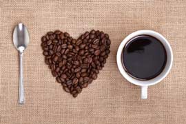 lyžička, srdiečko zo zrnkovej kávy a šálka kávy tvoriace nápis I love coffee