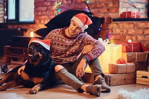 muž so psom pri vianočnom stromčeku