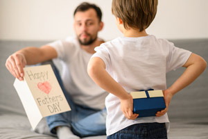 chlapček dáva darček otcovi ku Dňu otcov