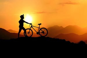 Hurá na bicykel! Nezabudnite na základnú cyklistickú výbavu Cyklista pri západe slnka