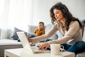 Spríjemnite si prácu z domu: Navrhnite si vlastný hrnček na kávu žena so synom pracuje z domu